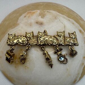 AJC Vintage gold-tone brooch with five cats and dangling charms.